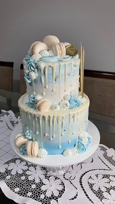 a three tiered cake with blue icing and seashells on the top