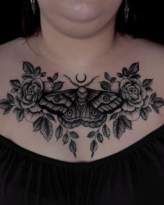 a woman's chest with a moth and roses tattoo on her chest, in front of the camera