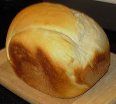 a loaf of bread sitting on top of a wooden cutting board