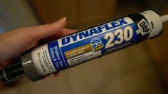 a person holding a can of dynaflex in their left hand and the other hand on top of it