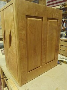 a large wooden cabinet sitting on top of a workbench in a shop or workshop