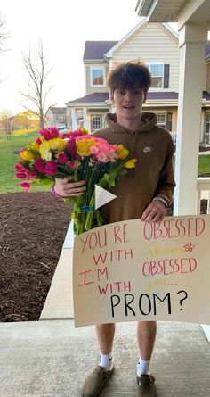 a person holding flowers and a sign that says, you're dressed with an i'm obsesed prom?