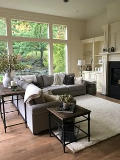 a living room filled with furniture and a fire place in front of a large window