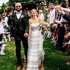 a bride and groom walk down the aisle as confetti is thrown around them