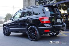 a black suv parked in front of a building