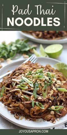 pad thai noodles on a white plate with limes