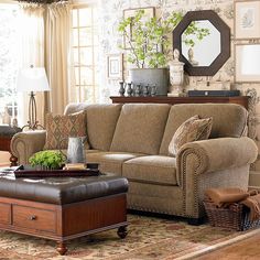 a living room filled with furniture and a large mirror on the wall above it's headboard