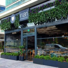 an outside view of a restaurant with plants growing on the windows