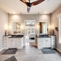 a large bathroom with two sinks and a ceiling fan in the middle of the room