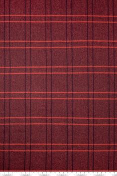 a red and black plaid fabric with a ruler in front of the bottom right corner