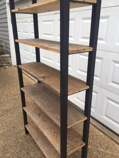 the shelves are made out of wood and black metal pipe, which is attached to a garage door