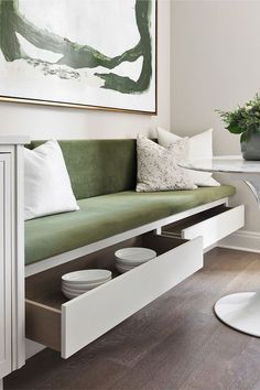 a living room with a green couch and some white plates on the coffee table in front of it