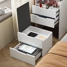 two drawers are open on the side of a bed