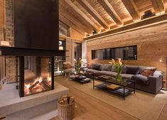 a living room with a fire place in the center and wooden walls on both sides