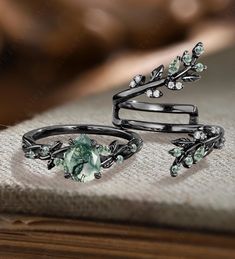 two rings with green stones and leaves on them