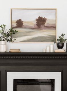 a fireplace with a painting on the mantle and potted plants in front of it