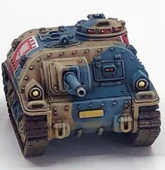 a close up of a toy tank on a white surface