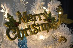 a white christmas tree with gold and blue decorations