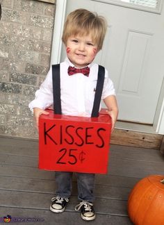 a little boy dressed up as kisses and holding a red box with the number twenty five on it