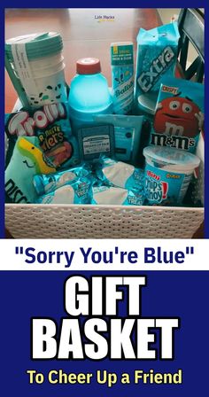 a basket filled with lots of different items next to a sign that says sorry you're blue gift basket to cheer up a friend