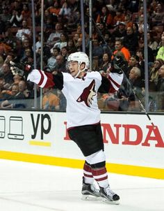 a hockey player holding his arms up in the air