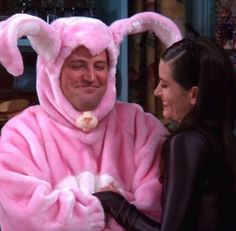 a man in a pink bunny costume standing next to a woman