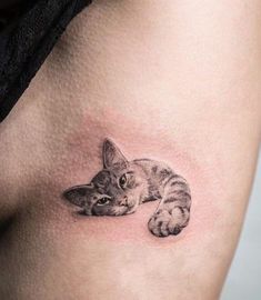 a small cat tattoo on the thigh