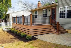 a house with a deck and railing in the front yard