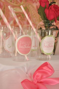 pink and green striped straws in plastic cups with happy birthday stickers on them