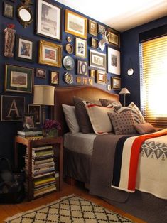 a bed room with a neatly made bed and lots of pictures on the wall above it