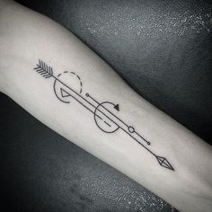 a black and white photo of a person's arm with an arrow tattoo on it