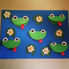 paper cut out of frogs and flowers on a blue mat