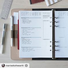 an open planner sitting on top of a wooden table