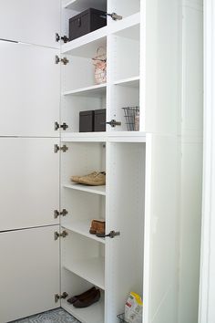 a white closet with shelves and shoes in it