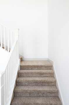 an empty room with carpeted stairs and white walls