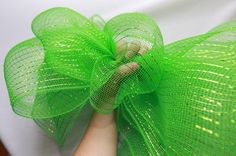 a woman is wearing a green mesh bow