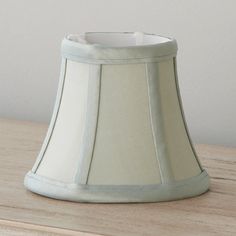 a white lamp shade sitting on top of a wooden table