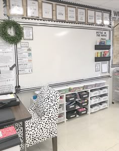 a whiteboard in the middle of a room with several bins and chairs around it