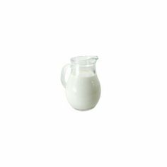 a glass pitcher filled with milk on top of a white table