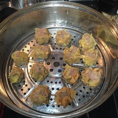 some dumplings are cooking in a pan on top of the stove burners,