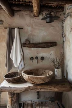 a rustic bathroom with an old sink and wooden counter top, along with two towels hanging on the wall