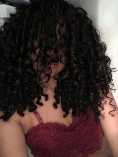 a woman with curly hair wearing a red bra