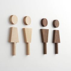 four wooden figures are arranged on a white surface