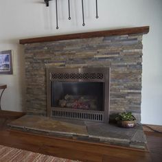 a living room with a fire place in the center and a rug on the floor