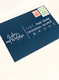 a blue envelope with the date and stamp on it is sitting on a white surface