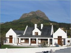 a white house with mountains in the background