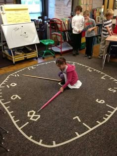 an image of a child playing on the floor in front of a large clock with numbers