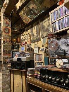 a room filled with lots of different types of audio equipment and bookshelves full of cds