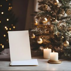 a christmas tree with lit candles and a white sheet of paper on the table next to it