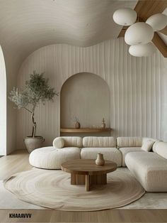 a living room with white couches and round tables